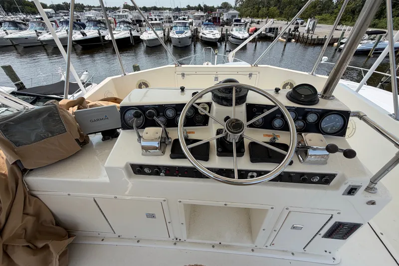 Slide: The Image of 1989 Egg Harbor 41 Convertible yacht helm with steering wheel and navigation equipment at marina. - 36