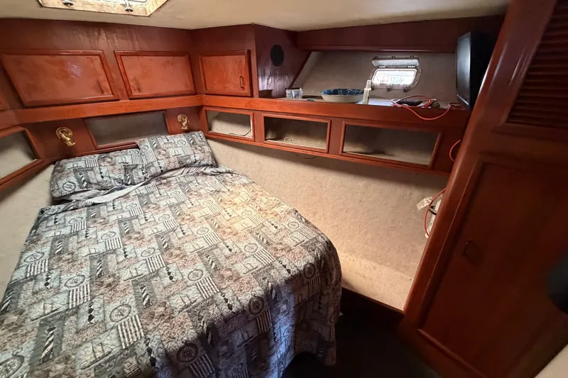Slide: The Image of Cozy cabin interior of 1989 Egg Harbor 41 Convertible with wood paneling and patterned bedding. - 27