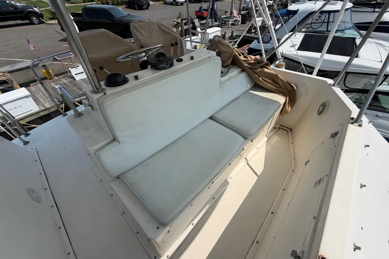 Slide: The Image of 1989 Egg Harbor 41 Convertible boat helm with cushioned seating and covered controls. - 37