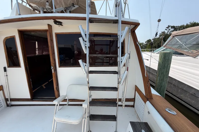 Slide: The Image of 1989 Egg Harbor 41 Convertible yacht deck with ladder and seating at marina. - 32