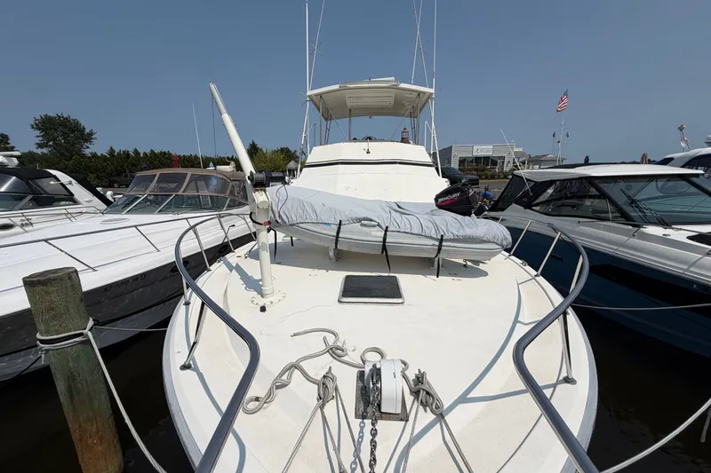 Slide: The Image of 1989 Egg Harbor 41 Convertible yacht docked at marina, showcasing spacious deck and sleek design. - 45