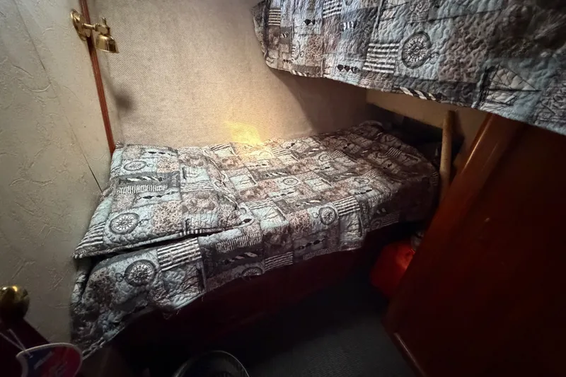 Slide: The Image of Cozy cabin bed in 1989 Egg Harbor 41 Convertible yacht, featuring patterned bedding. - 24