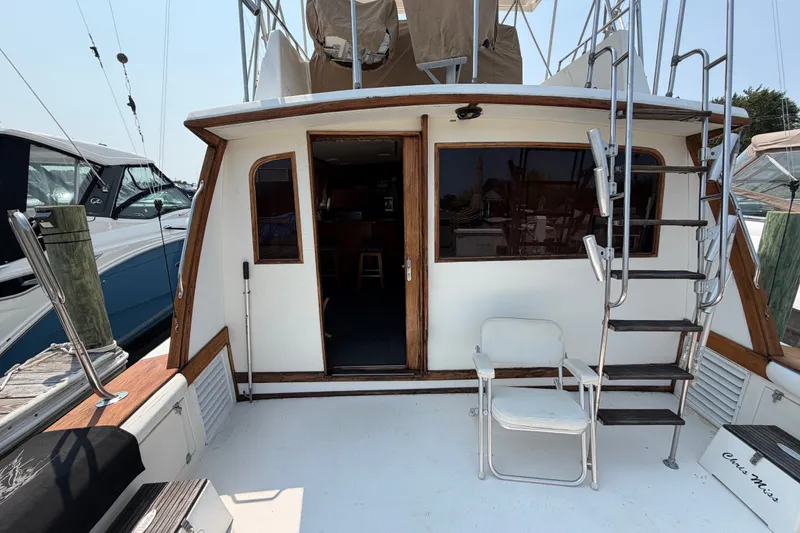 Slide: The Image of 1989 Egg Harbor 41 Convertible yacht with outdoor seating and ladder, docked at marina. - 10
