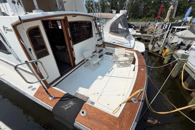 Slide: The Image of 1989 Egg Harbor 41 Convertible yacht docked, featuring spacious deck and seating area. - 8