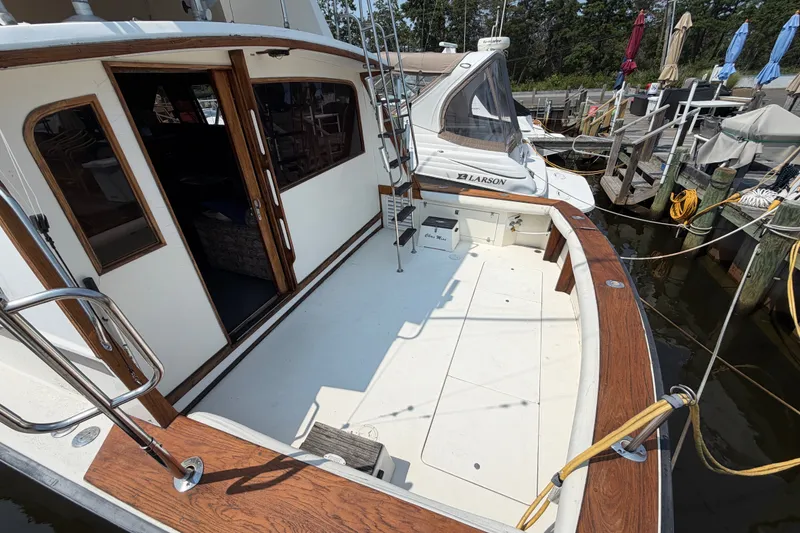 Slide: The Image of 1989 Egg Harbor 41 Convertible boat docked, featuring spacious deck and wooden accents. - 4