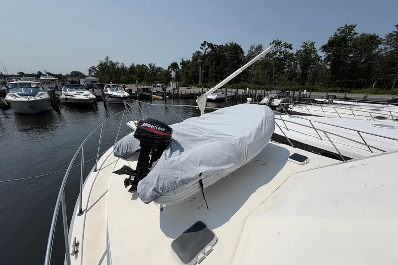 Slide: The Image of 1989 Egg Harbor 41 Convertible yacht with covered dinghy and Mercury outboard motor at marina. - 40