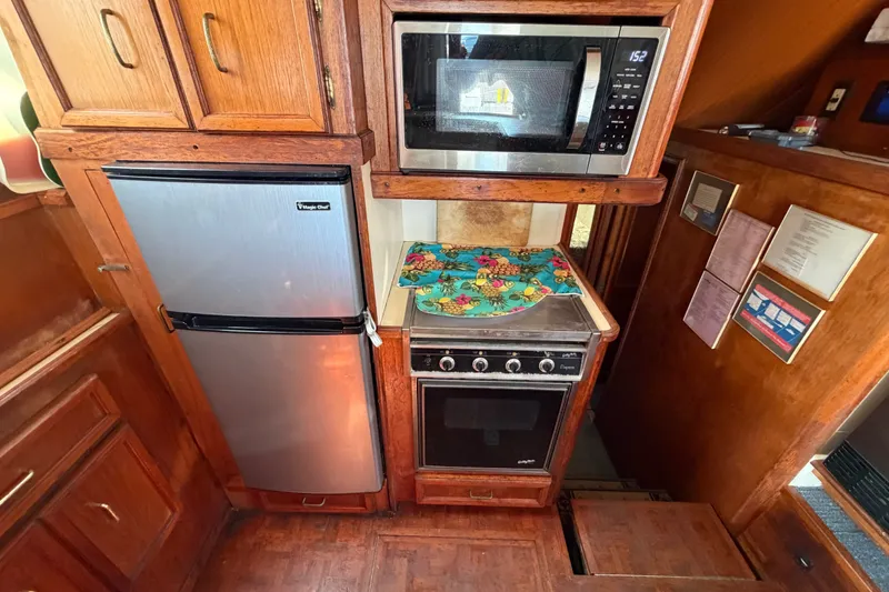 Slide: The Image of 1989 Egg Harbor 41 Convertible kitchen with microwave, fridge, and oven in wooden cabinetry. - 18