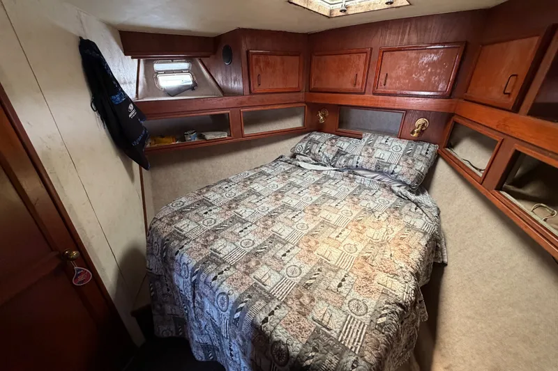 Slide: The Image of Cozy cabin interior of 1989 Egg Harbor 41 Convertible with patterned bedding and wooden storage. - 26