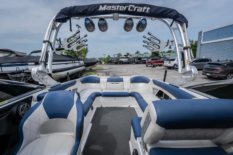 Slide: The Image of 2012 MasterCraft X55 boat interior with blue and white seating, docked at a marina. - 27