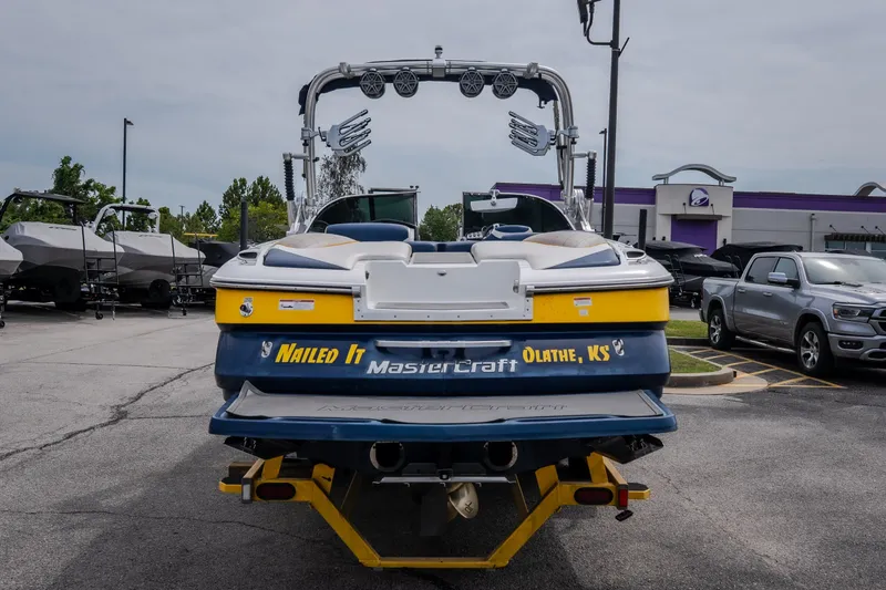 Slide: The Image of 2012 MasterCraft X55 boat with custom decals in a parking lot. - 2