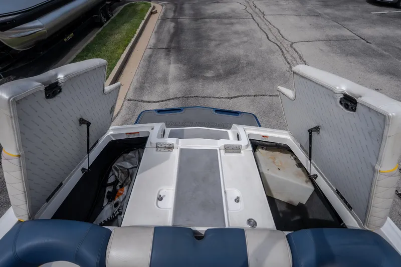 Slide: The Image of 2012 MasterCraft X55 boat storage compartments open, showcasing interior space and seating. - 47