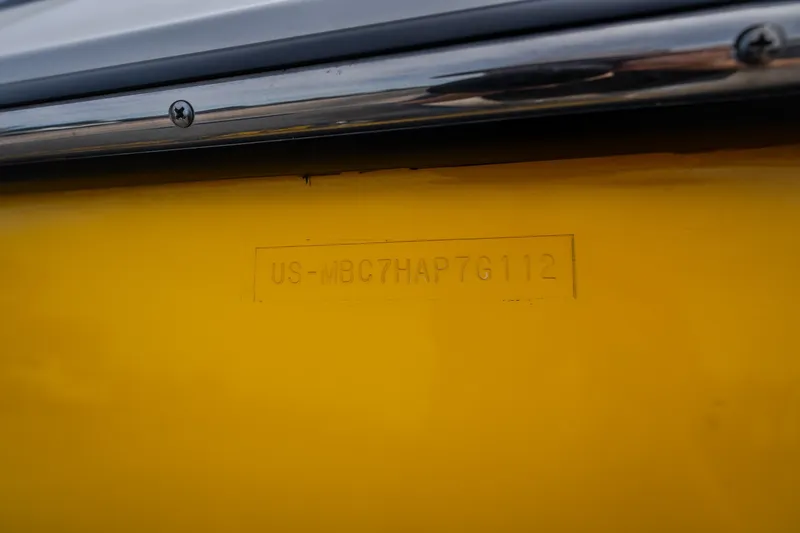 Slide: The Image of 2012 MasterCraft X55 boat hull identification number on yellow surface. - 16