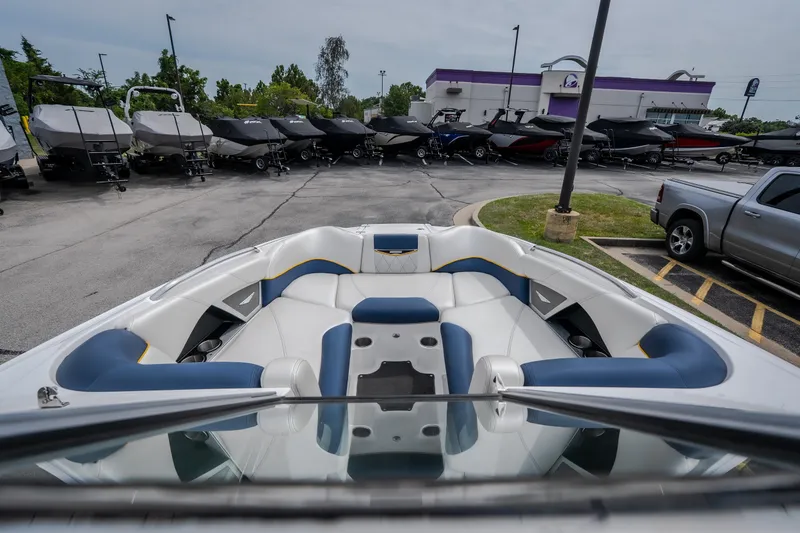 Slide: The Image of 2012 MasterCraft X55 boat interior with blue and white seating, parked in a dealership lot. - 29