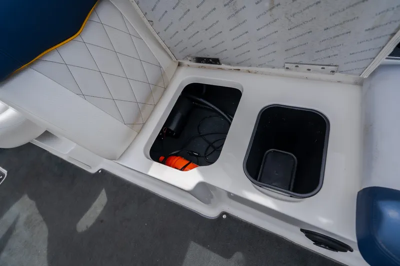 Slide: The Image of 2012 MasterCraft X55 boat storage compartments with open seat and visible wiring. - 52