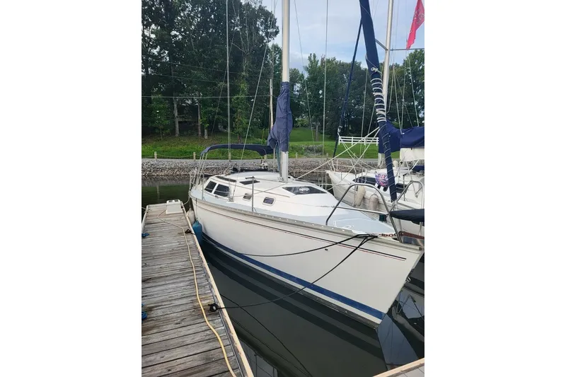 Slide: The Image of 1993 Hunter Marine 30 sailboat docked, featuring sleek design and blue accents. - 7