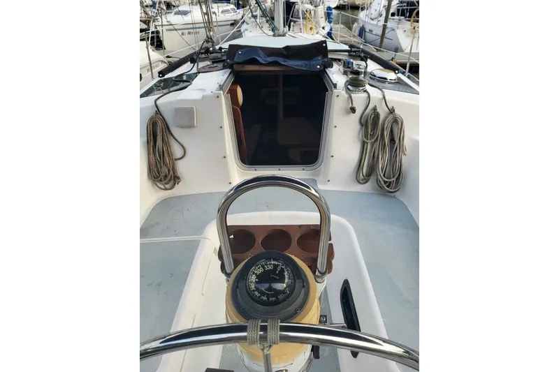 Slide: The Image of 1993 Hunter Marine 30 sailboat cockpit with compass, ropes, and open cabin entrance. - 10