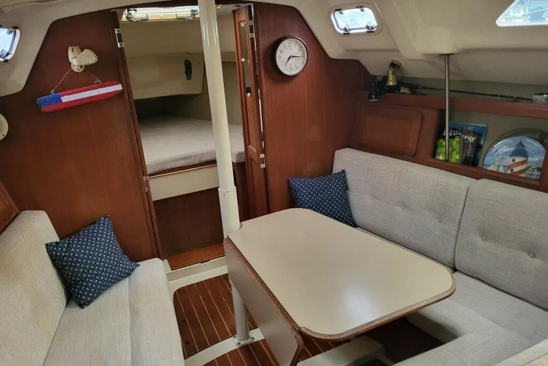 Slide: The Image of Cozy interior of a 1993 Hunter Marine 30 sailboat with seating and a table. - 9