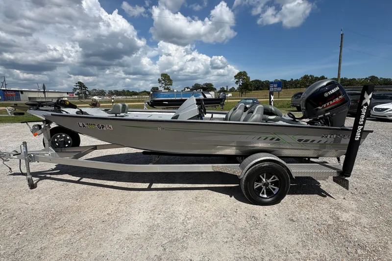 The Image of 2023 Xpress H18 boat on trailer with Yamaha engine, parked outdoors under cloudy sky. - 1