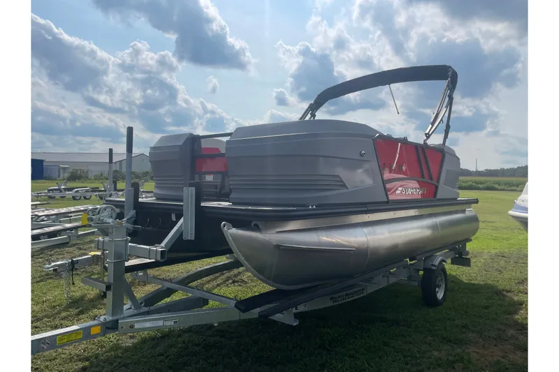 Slide: The Image of 2026 Starcraft GX 18 R pontoon boat on trailer under cloudy sky. - 5