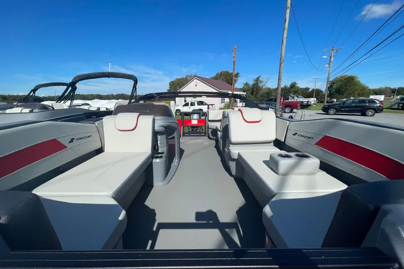 Slide: The Image of 2026 Starcraft GX 18 R boat interior with seating and cup holders under clear blue sky. - 1