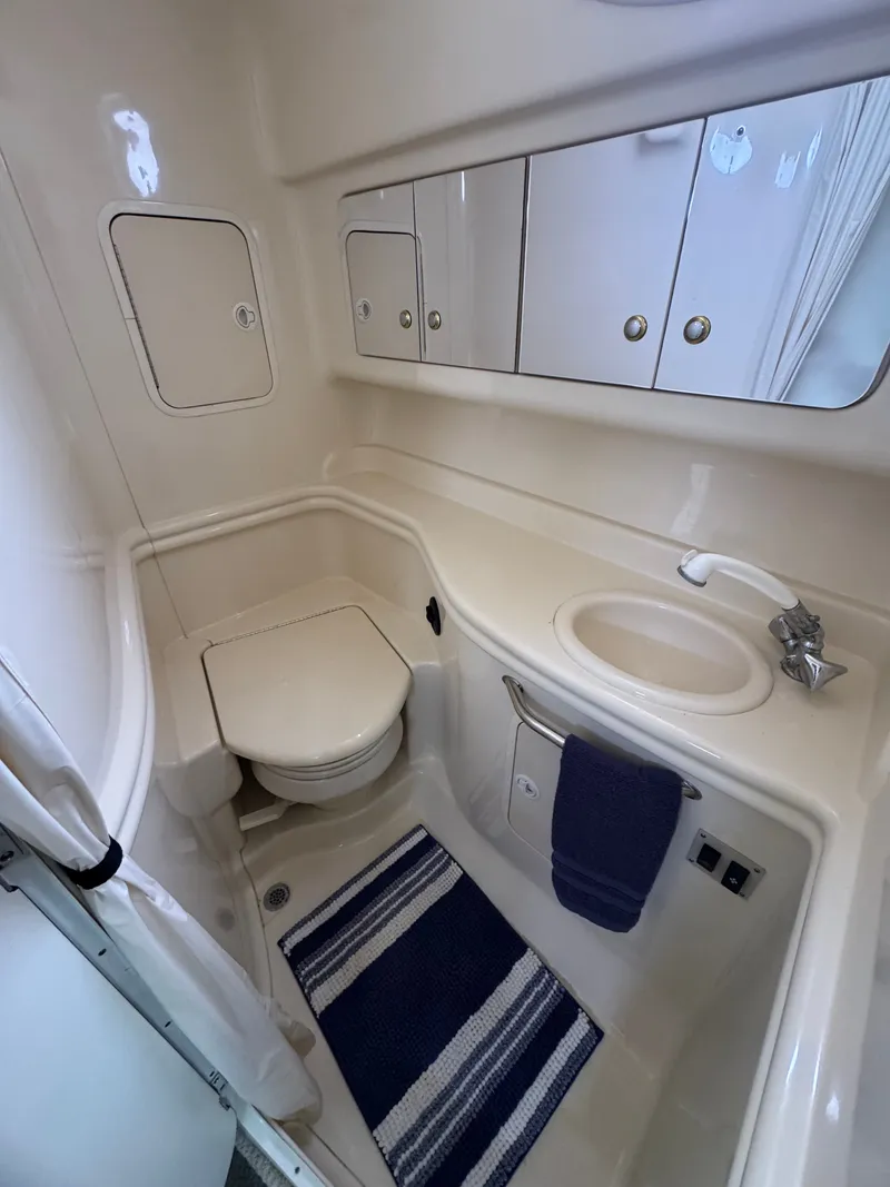 Slide: The Image of The image shows a boat bathroom with a toilet, sink, and mirror. - 14