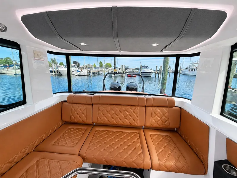 Slide: The Image of Interior of a 2022 Axopar Brabus 37 XC Cross Cabin with brown leather seating and harbor view. - 23