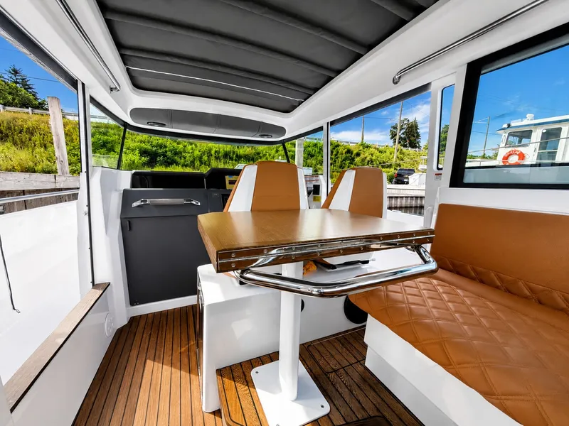 Slide: The Image of Interior of the 2022 Axopar Brabus 37 XC Cross Cabin with a wooden table and brown seats. - 21