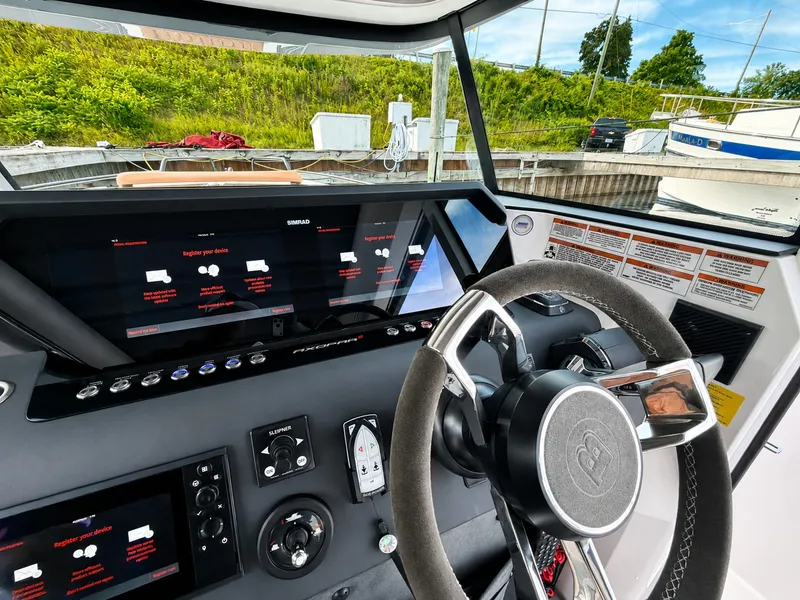 Slide: The Image of The cockpit of the 2022 Axopar Brabus 37 XC Cross Cabin features modern instruments and a sleek steering wheel. - 26