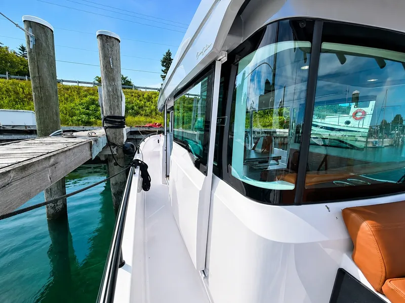Slide: The Image of A 2022 Axopar Brabus 37 XC Cross Cabin docked at a wooden pier. The cabin features large windows. - 15