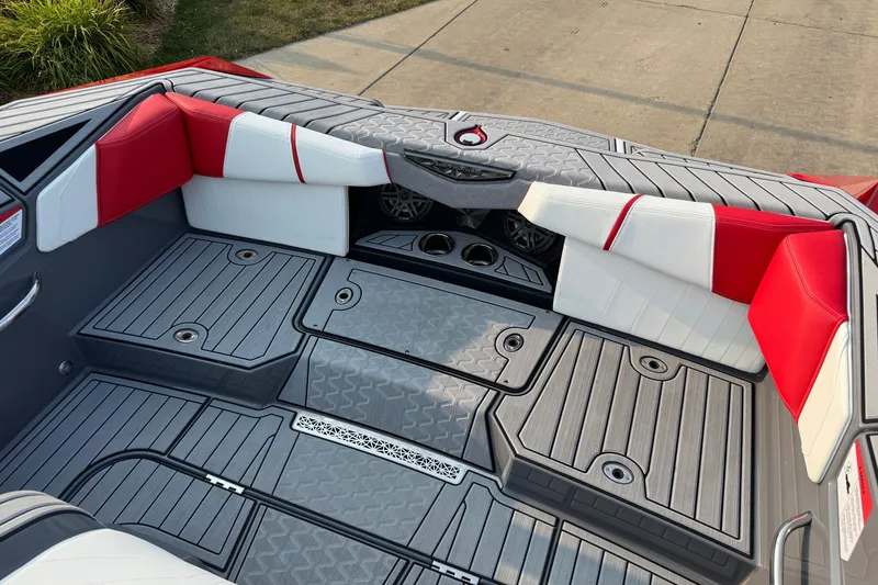 Slide: The Image of 2024 Nautique Ski Nautique boat interior with red and white seating and gray flooring. - 15