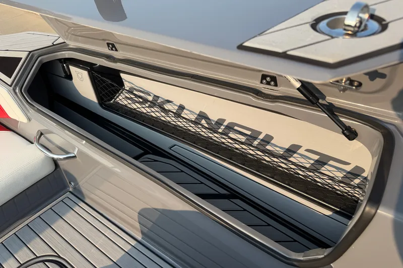 Slide: The Image of 2024 Nautique Ski Nautique storage compartment with open lid and interior view. - 21