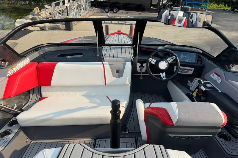 Slide: The Image of 2024 Nautique Ski Nautique interior with red and white seating, modern dashboard, and steering wheel. - 28