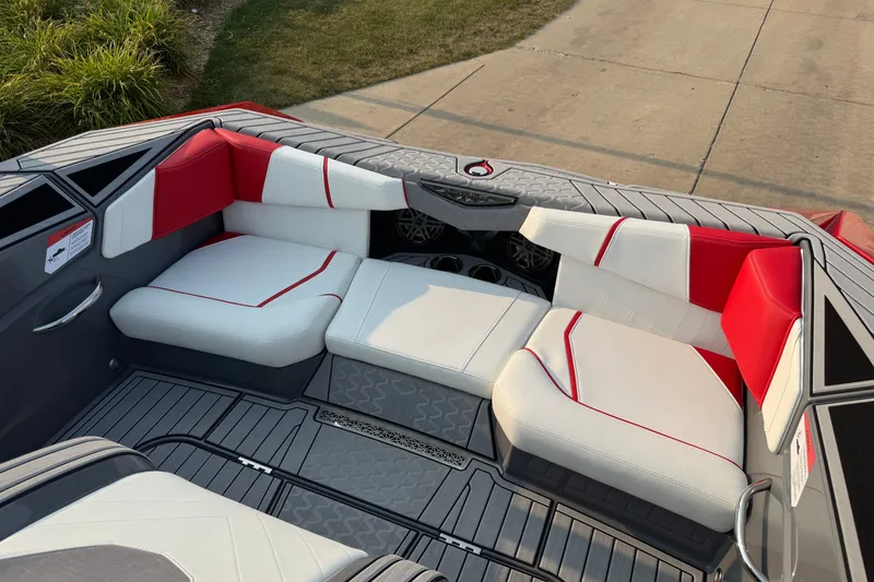 Slide: The Image of 2024 Nautique Ski Nautique boat interior with red and white seating, gray flooring. - 13