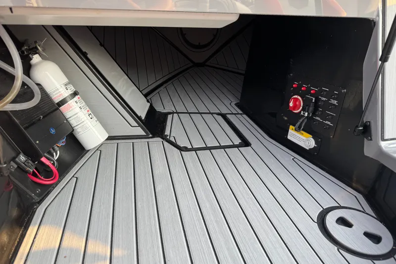 Slide: The Image of 2024 Nautique Ski Nautique interior with fire extinguisher and control panel, featuring sleek flooring. - 31