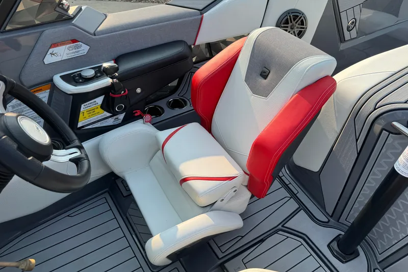 Slide: The Image of 2024 Nautique Ski Nautique interior with red and white captain's seat and control panel. - 33