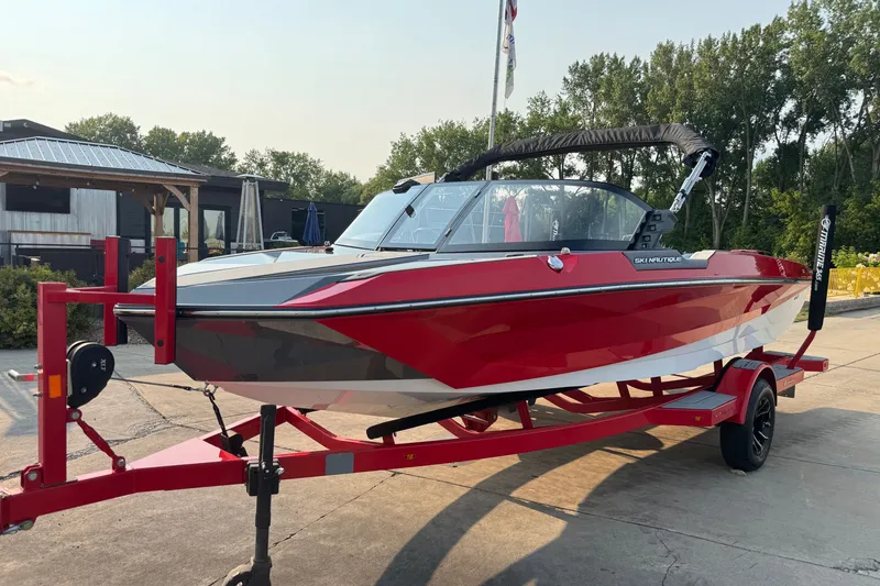 Slide: The Image of 2024 Nautique Ski Nautique boat on trailer, red and white design, outdoor setting. - 1