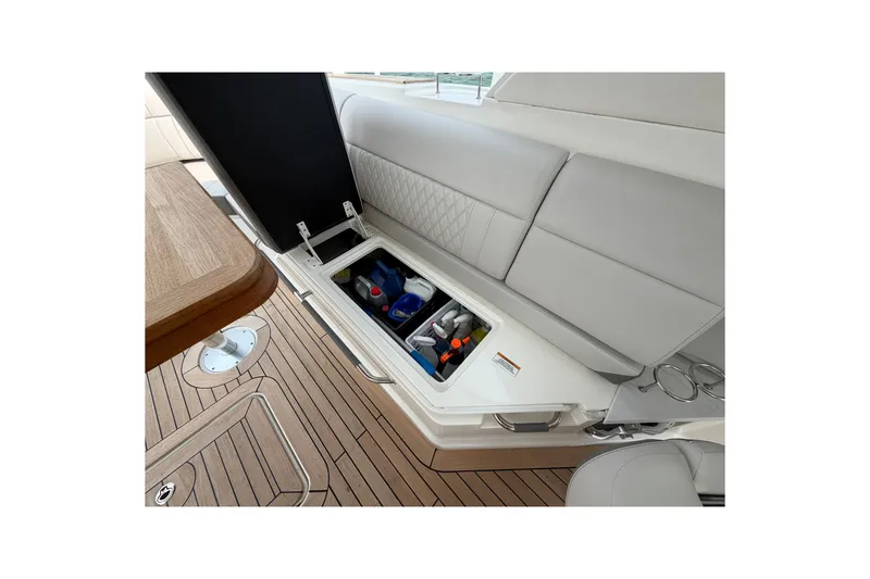 Slide: The Image of 2023 Sea Ray SLX 400 boat interior storage compartment with open lid on wooden deck. - 34