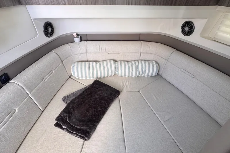 Slide: The Image of Cozy interior of 2023 Sea Ray SLX 400 with plush seating and striped pillows. - 37