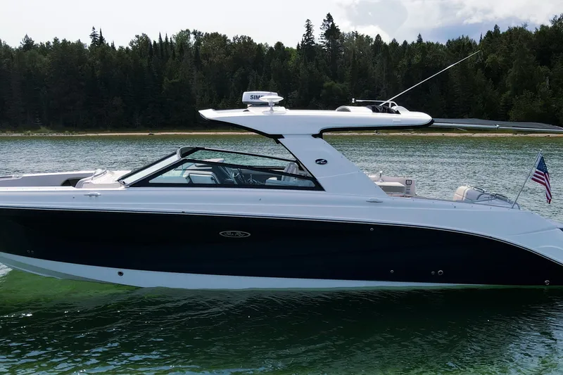 Slide: The Image of 2023 Sea Ray SLX 400 boat on a serene lake with forested background. - 1