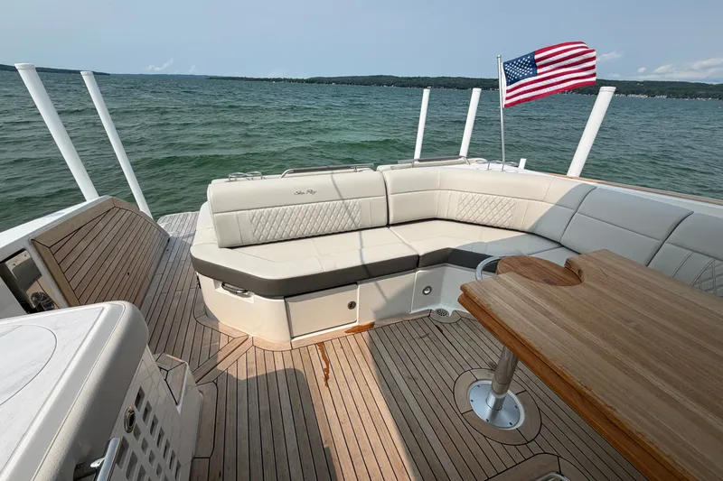Slide: The Image of 2023 Sea Ray SLX 400 boat interior with seating, wooden deck, and American flag. - 27