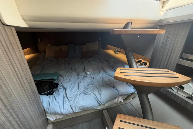 Slide: The Image of Interior cabin of 2023 Sea Ray SLX 400 with cozy bedding and wooden steps. - 40