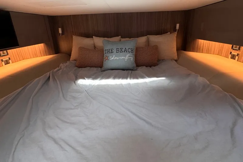Slide: The Image of Cozy cabin bed in 2023 Sea Ray SLX 400 yacht with decorative pillows. - 38