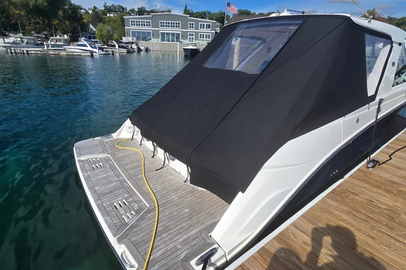 Slide: The Image of 2023 Sea Ray SLX 400 yacht docked with black canopy and wooden deck. - 47