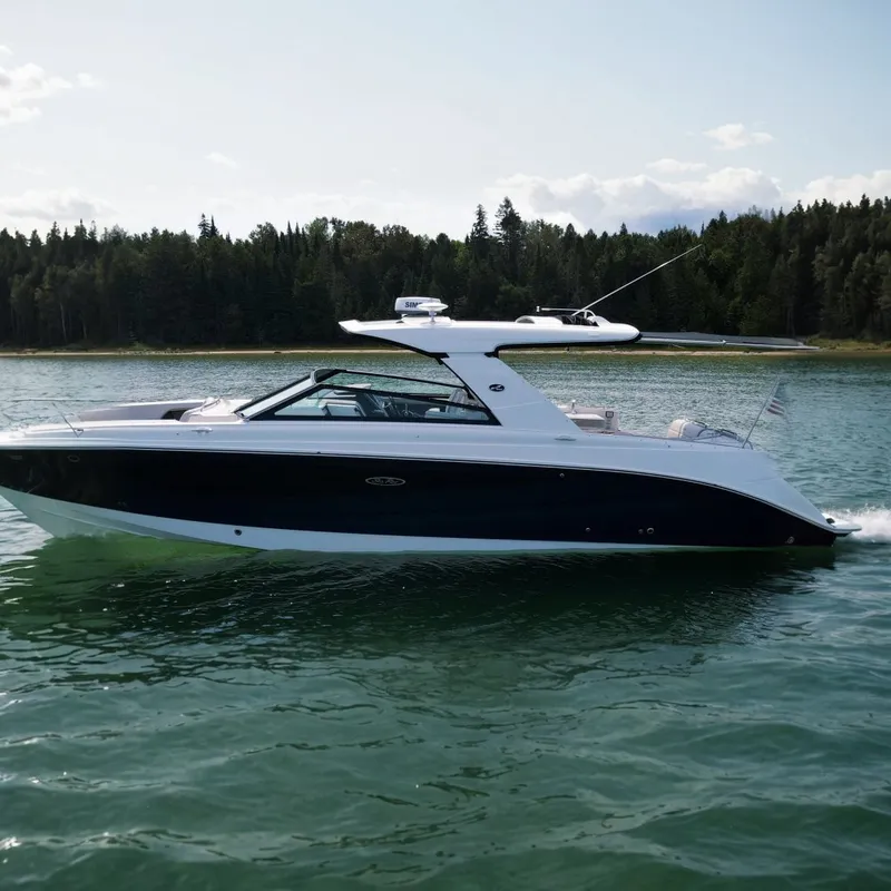 The Image of The 2023 Sea Ray SLX 400 cruising on calm waters near a wooded shoreline. - 0