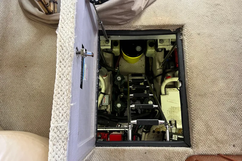 Slide: The Image of Engine compartment of a 2003 Sea Ray 480 Motor Yacht, showing mechanical components and access hatch. - 52