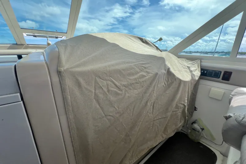 Slide: The Image of 2003 Sea Ray 480 Motor Yacht helm covered, with clear sky and ocean view. - 165