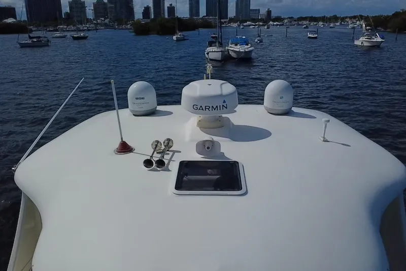 Slide: The Image of 2003 Sea Ray 480 Motor Yacht with Garmin equipment, docked in a marina with city skyline. - 208