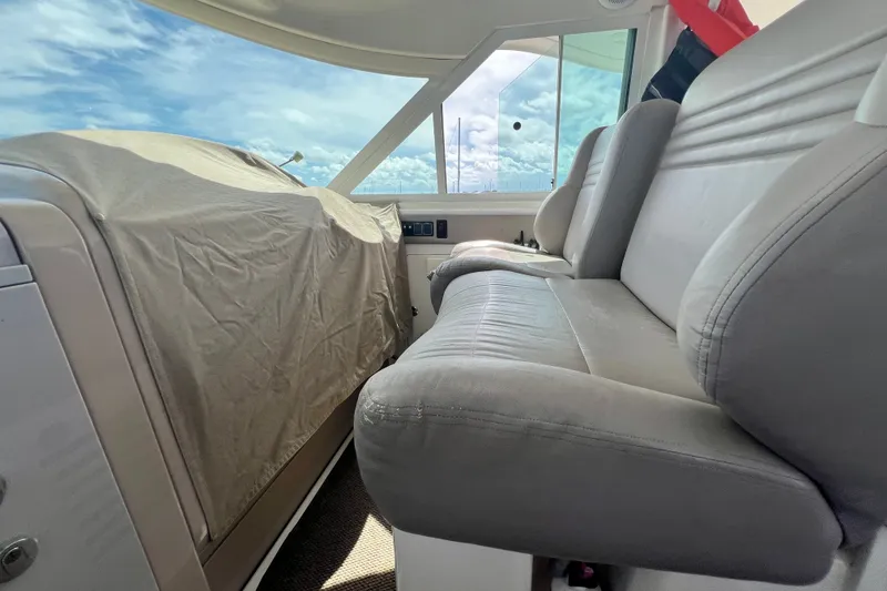 Slide: The Image of Interior of 2003 Sea Ray 480 Motor Yacht with covered controls and cushioned seating. - 164