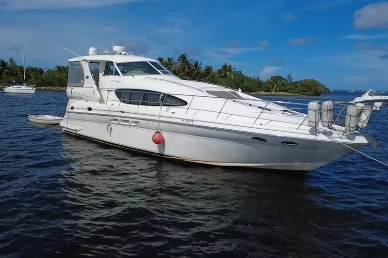 Slide: The Image of 2003 Sea Ray 480 Motor Yacht on calm water, tropical backdrop, clear blue sky. - 4