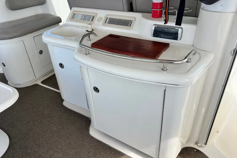 Slide: The Image of 2003 Sea Ray 480 Motor Yacht interior with sink, cutting board, and storage cabinets. - 177